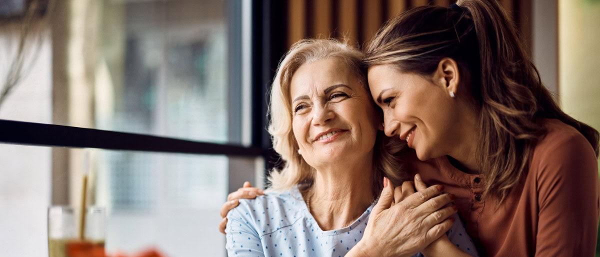 Two women smiling and hugging