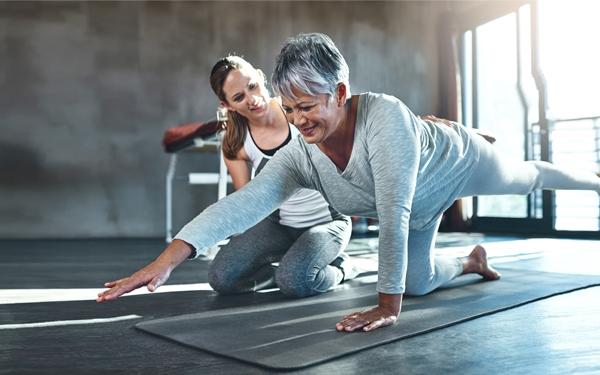 Personal trainer training an older woman