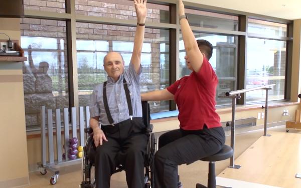 Physiotherapist demonstrating exercise to patient