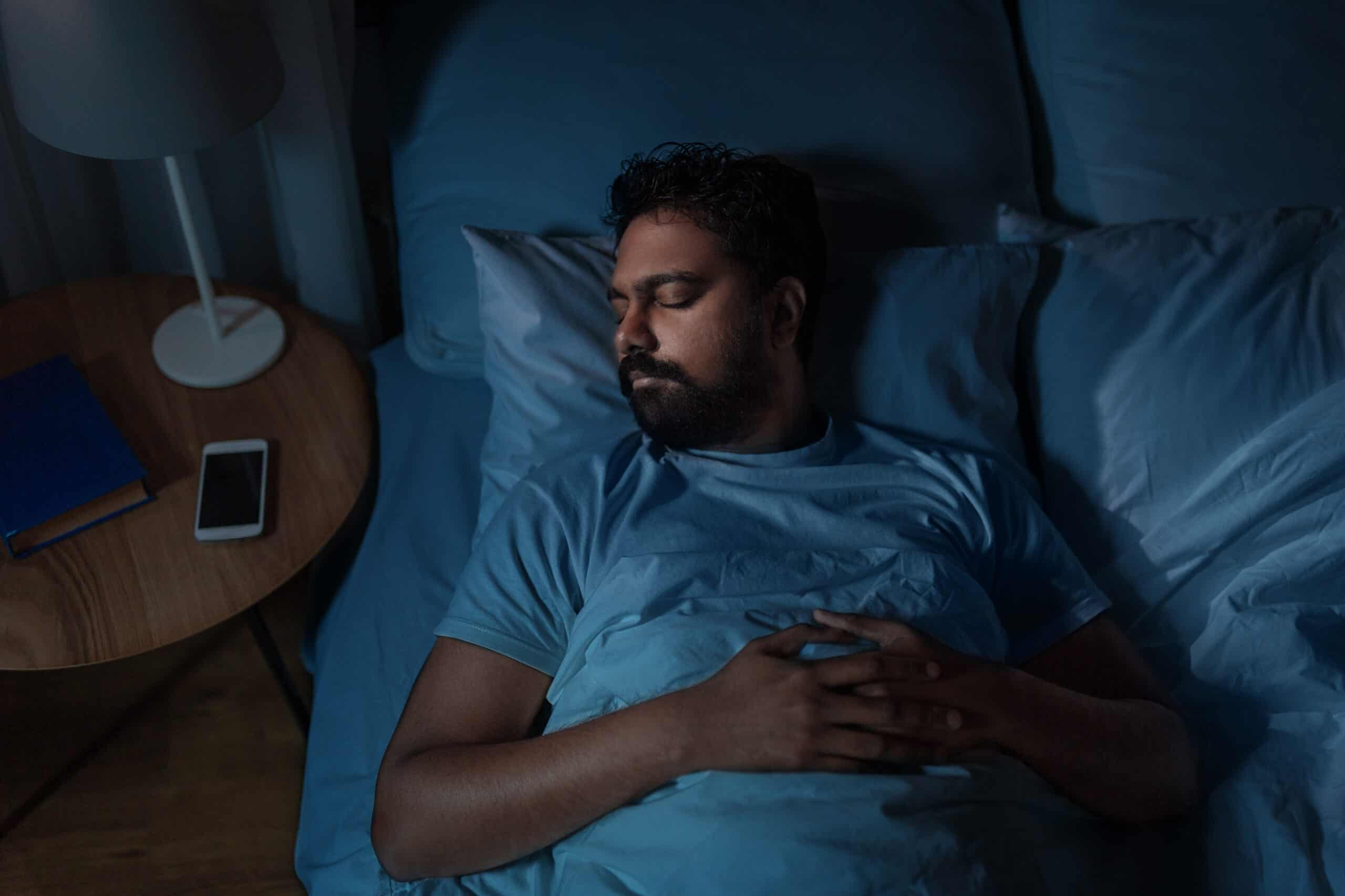 indian man sleeping in bed at home at night