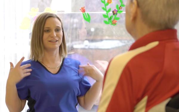 Personal support worker talking to patient in wheelchair